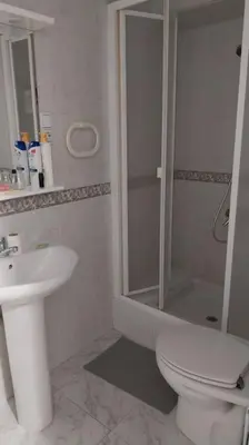 a bathroom with a shower and a toilet and a sink at Santa Marta frente al mar in Cullera