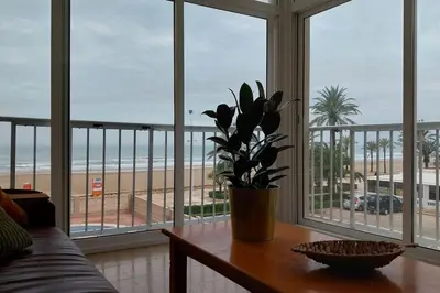 a living room with a table and a view of the beach at Santa Marta frente al mar in Cullera