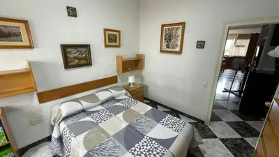 a bedroom with a bed in the corner of a room at flat family near center and jardin turia avenida del cid in Valencia