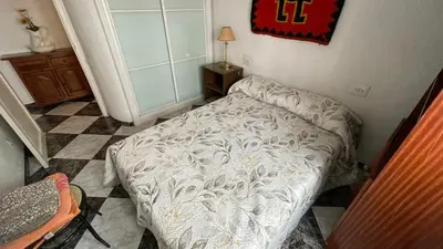 a bedroom with a bed in the corner of a room at flat family near center and jardin turia avenida del cid in Valencia