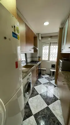 a kitchen with a refrigerator and a tile floor at flat family near center and jardin turia avenida del cid in Valencia