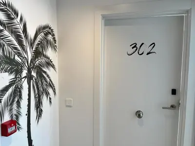 a door with a palm tree stencil on the wall at Lumen Mare by SH Hoteles in Valencia
