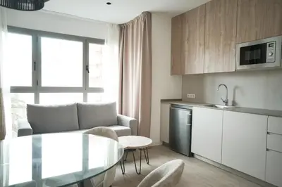 a kitchen and living room with a table and chairs at Lumen Mare by SH Hoteles in Valencia