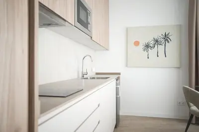 a white kitchen with a sink and a microwave at Lumen Mare by SH Hoteles in Valencia