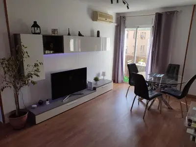 a living room with a flat screen tv and a table at Bedroom to rent in the beach in Valencia
