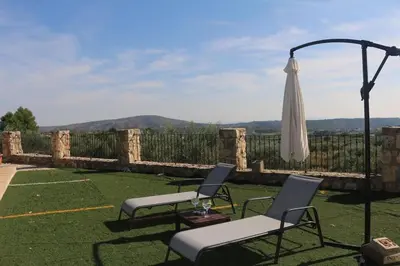 a patio with two chairs and an umbrella at Casa El Calderon in Chella