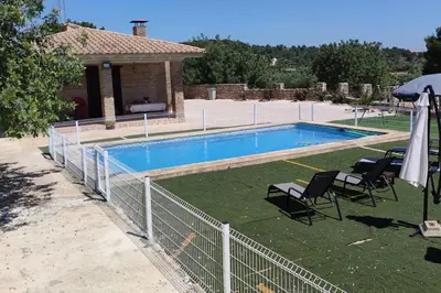 a swimming pool with two chairs and an umbrella at Casa El Calderon in Chella