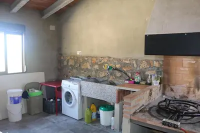 a kitchen with a stove and a washing machine at Casa El Calderon in Chella