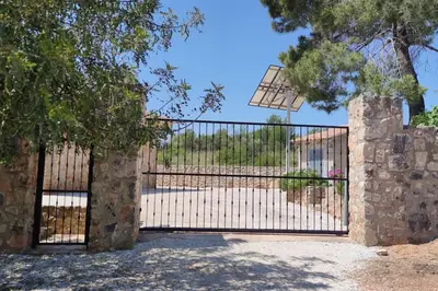 an iron gate with a stone pillar at Casa El Calderon in Chella