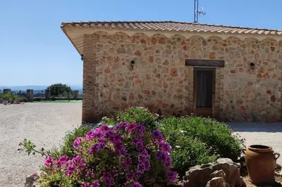 a brick building with purple flowers in front of it at Casa El Calderon in Chella