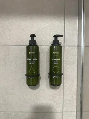 two green bottles on the wall of a bathroom at Arena 20 Suites in Valencia