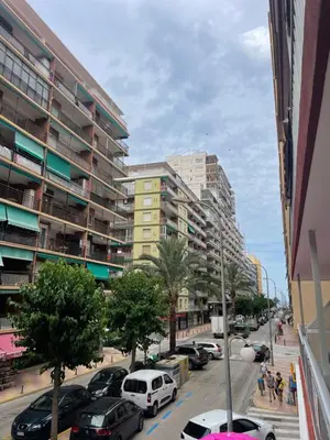 a city street with cars parked in front of tall buildings at Apartamento de lujo en Cullera con Aire Acondicionado in Cullera