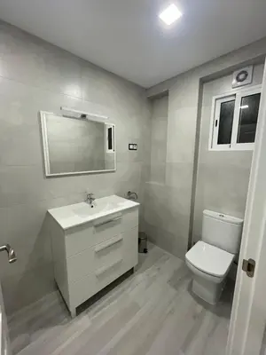 a bathroom with a white sink and a toilet at Apartamento de lujo en Cullera con Aire Acondicionado in Cullera