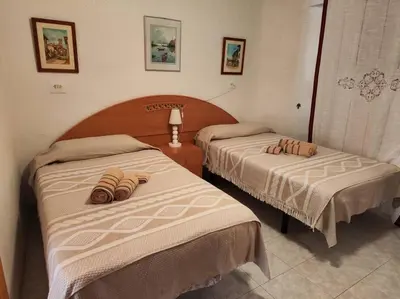 two beds in a hotel room with towels on them at Encantador piso cerca de la playa en Cullera in Faro de Cullera