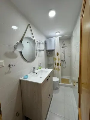 a bathroom with a sink and a toilet and a mirror at Encantador piso cerca de la playa en Cullera in Faro de Cullera