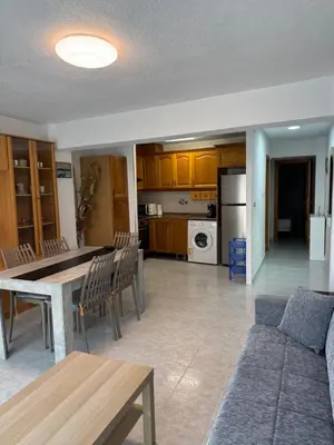 a kitchen and living room with a table and chairs at Encantador piso cerca de la playa en Cullera in Faro de Cullera