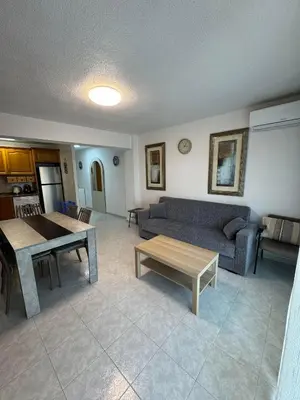 a living room with a couch and a table at Encantador piso cerca de la playa en Cullera in Faro de Cullera