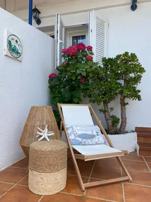 a chair sitting next to a table and flowers at Hostal Blayet - Hostal Automatizado in Valencia