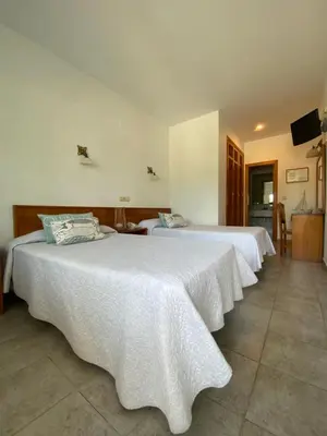 two beds in a hotel room with white sheets at Hostal Blayet - Hostal Automatizado in Valencia