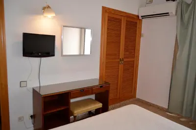 a bedroom with a desk and a television on a wall at Hostal Blayet - Hostal Automatizado in Valencia