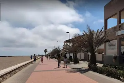 a group of people walking on a sidewalk near the beach at Bali Beach Puzol relax en la playa cerca de Sagunto y Valencia in Puzol