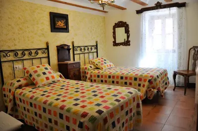 a bedroom with two beds in a room at Casa rural La Boticaria in Villar del Arzobispo