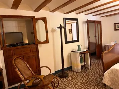 a room with a bedroom with a bed and a mirror at Casa rural La Boticaria in Villar del Arzobispo