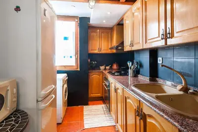 a large kitchen with wooden cabinets and a sink at Attic Duplex Ruzafa in Valencia