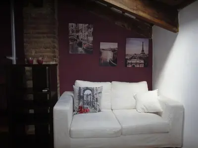a white couch in a living room with pictures on the wall at Attic Duplex Ruzafa in Valencia