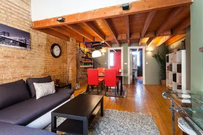 a living room with a couch and red chairs at Attic Duplex Ruzafa in Valencia