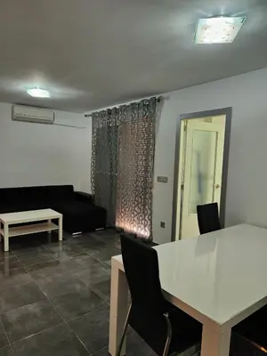 a living room with a black couch and a table at Mar i piscina Canet playa in Canet de Berenguer