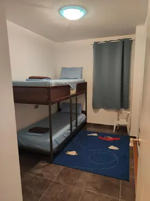 a room with a bunk bed and a blue rug at Mar i piscina Canet playa in Canet de Berenguer