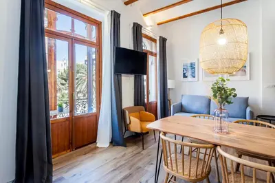 a dining room with a table and chairs and a window at Puerto Beach suites in Valencia