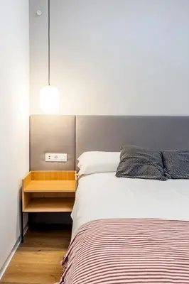 a bedroom with a large bed and a night stand at Puerto Beach suites in Valencia