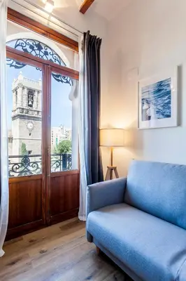 a living room with a blue couch and a window at Puerto Beach suites in Valencia