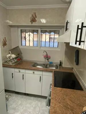 a kitchen with white cabinets and a sink at Beautiful apartment 1 minute walk to the beach in Puerto de Sagunto