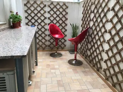 two red chairs sitting on a tile floor in a kitchen at City center where Falla starts in Valencia