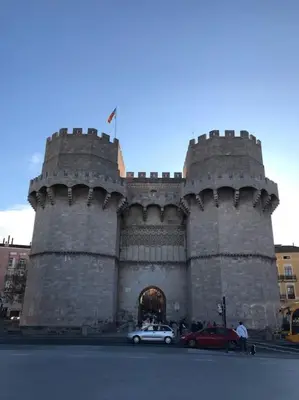 a large castle with cars parked in front of it at City center where Falla starts in Valencia