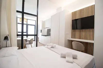 a white bedroom with a large bed with two towels at Maritim 2 by Concept Flats in Valencia