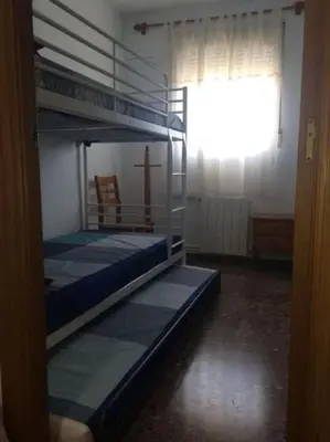 two bunk beds in a room with a window at Apartamento cómodo y espacioso con parking in Valencia