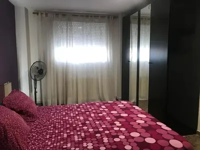 a bedroom with a pink bed with a window at Apartamento cómodo y espacioso con parking in Valencia