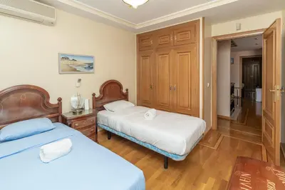 a bedroom with two beds and a wooden cabinet at GuestReady - A un paso del Mediterráneo in El Puig