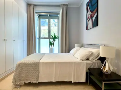 a bedroom with a white bed with a window at Reinapart Patacona Beachfront Seaview in Valencia