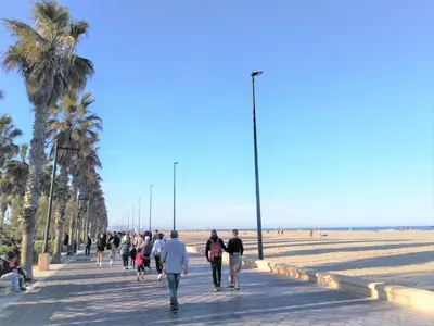 a group of people walking down a sidewalk near the beach at Habitación en Playa Malvarrosa con baño privado -No AC- in Valencia