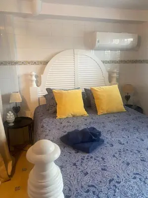 a bedroom with a large bed with yellow pillows at Casa Ellenita in Las Canteras