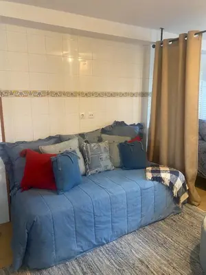 a blue couch with pillows on it in a room at Casa Ellenita in Las Canteras
