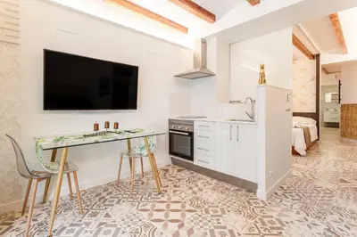 a kitchen with a counter and a sink and a tv at LOFT RUZAFA PLUS in Valencia