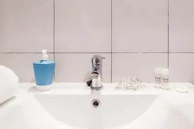 a bathroom sink with a faucet and a bottle of soap at LOFT RUZAFA PLUS in Valencia