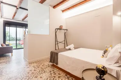a bedroom with a large bed and a living room at LOFT RUZAFA PLUS in Valencia