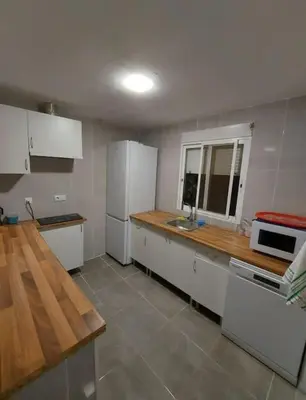 a kitchen with white appliances and a wooden counter top at Casa Tena in Partida de La Cañada